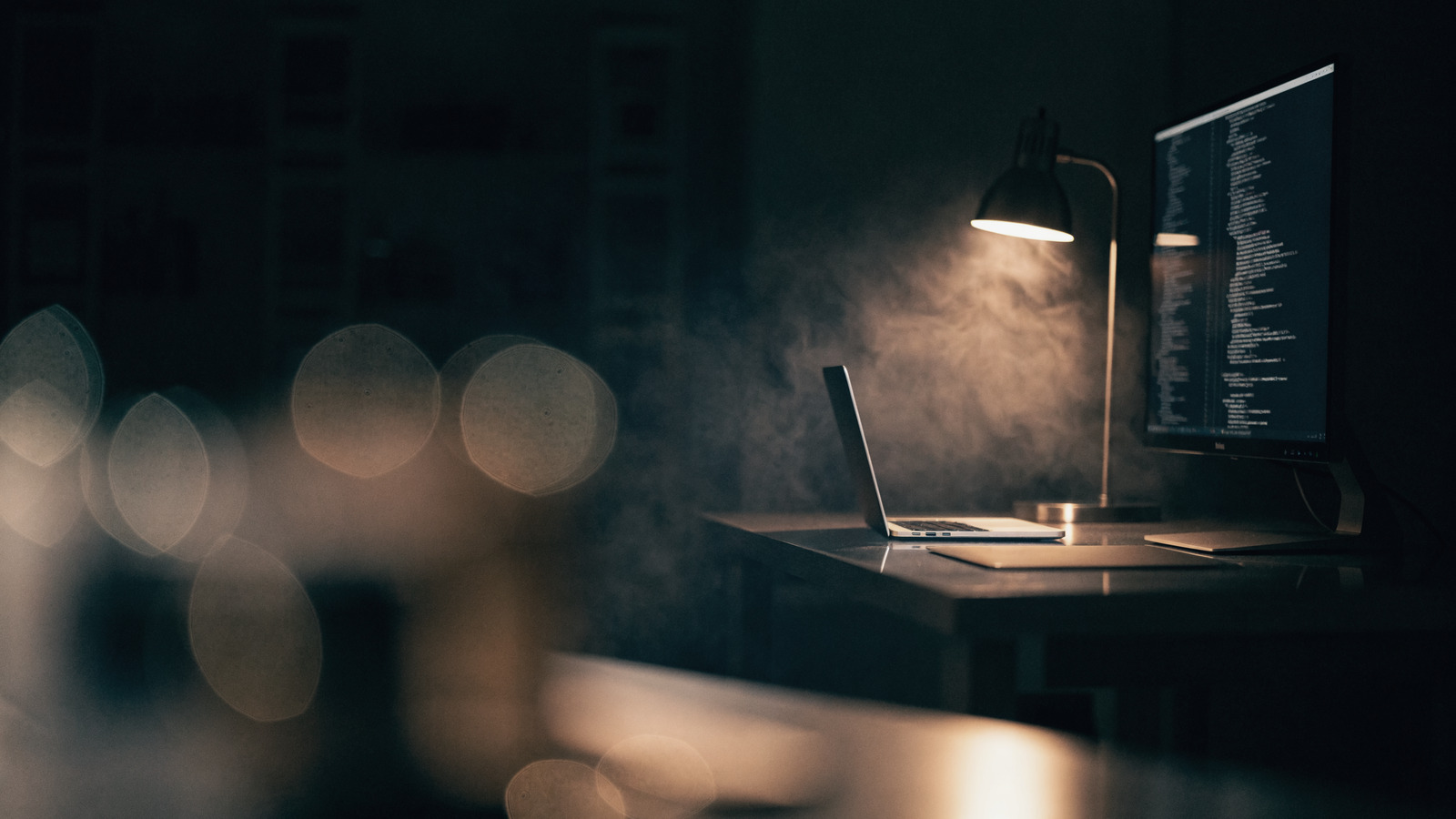 Bernds Workspace bei Nacht: Laptop und Monitor mit Code